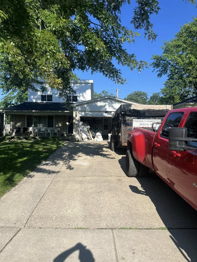Friendly Dumpster Rental truck delivering dumpster to Metro Detroit residential home